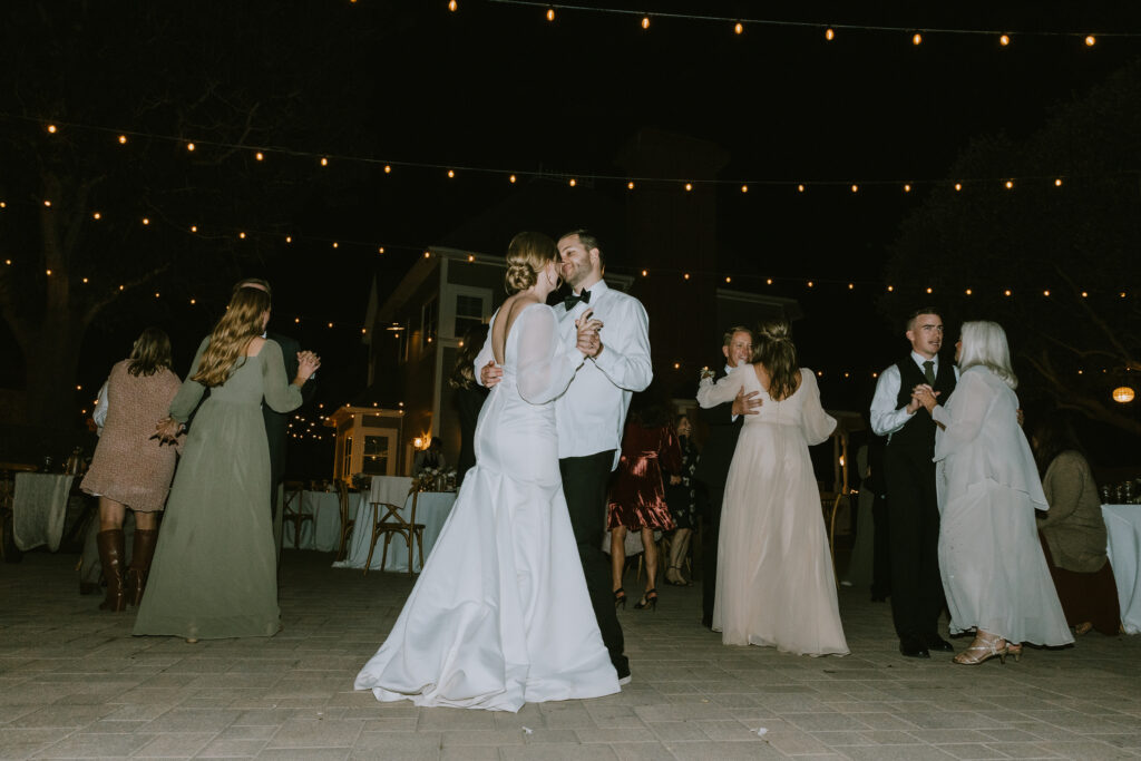 bride and groom dancing with siblings, parents, and grandparents